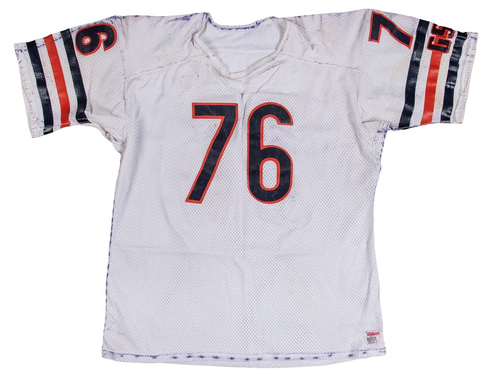 Close-up alternate angle of 1986 Steve McMichael game-used Chicago Bears jersey photo-matched to Super Bowl XX, detailed view of stitched #76, collar and sleeve wear, stitching and game stains visible alongside McMichael LOA, Resolution Photomatching & Beckett authentication