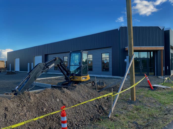 Finished navy metal commercial building with site work wrapping up