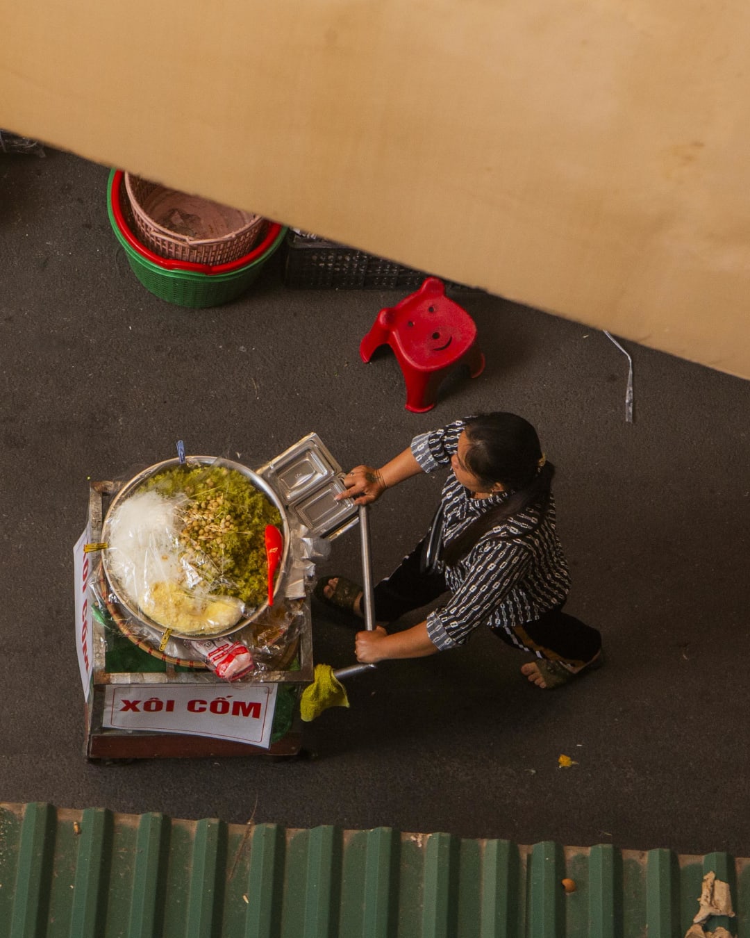 Overhead view of a street food vendor preparing xoi