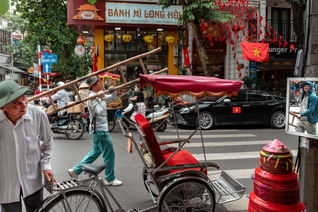 A cyclo loaded with goods on a city street