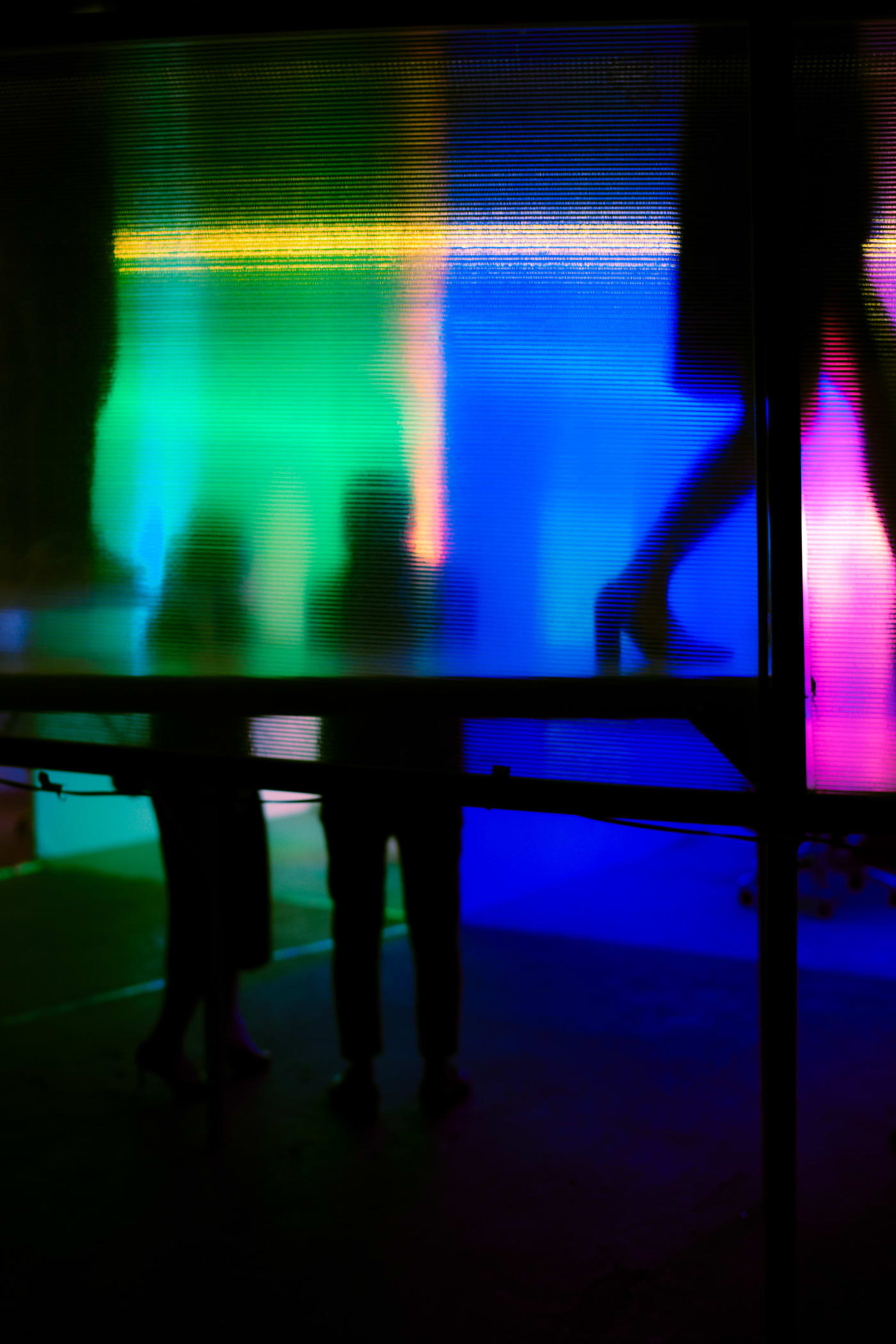 Neon silhouette through corrugated screen at night — Le Hoang Tuan