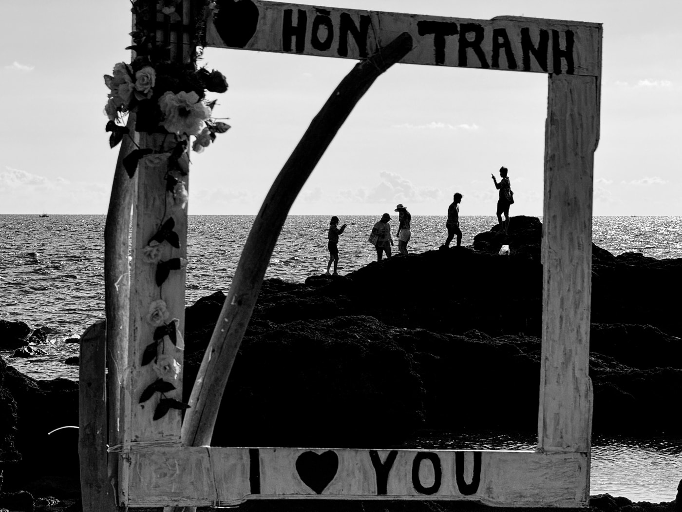 Tourists on the rocks framed by the Hon Tranh photo frame — Le Hoang Tuan