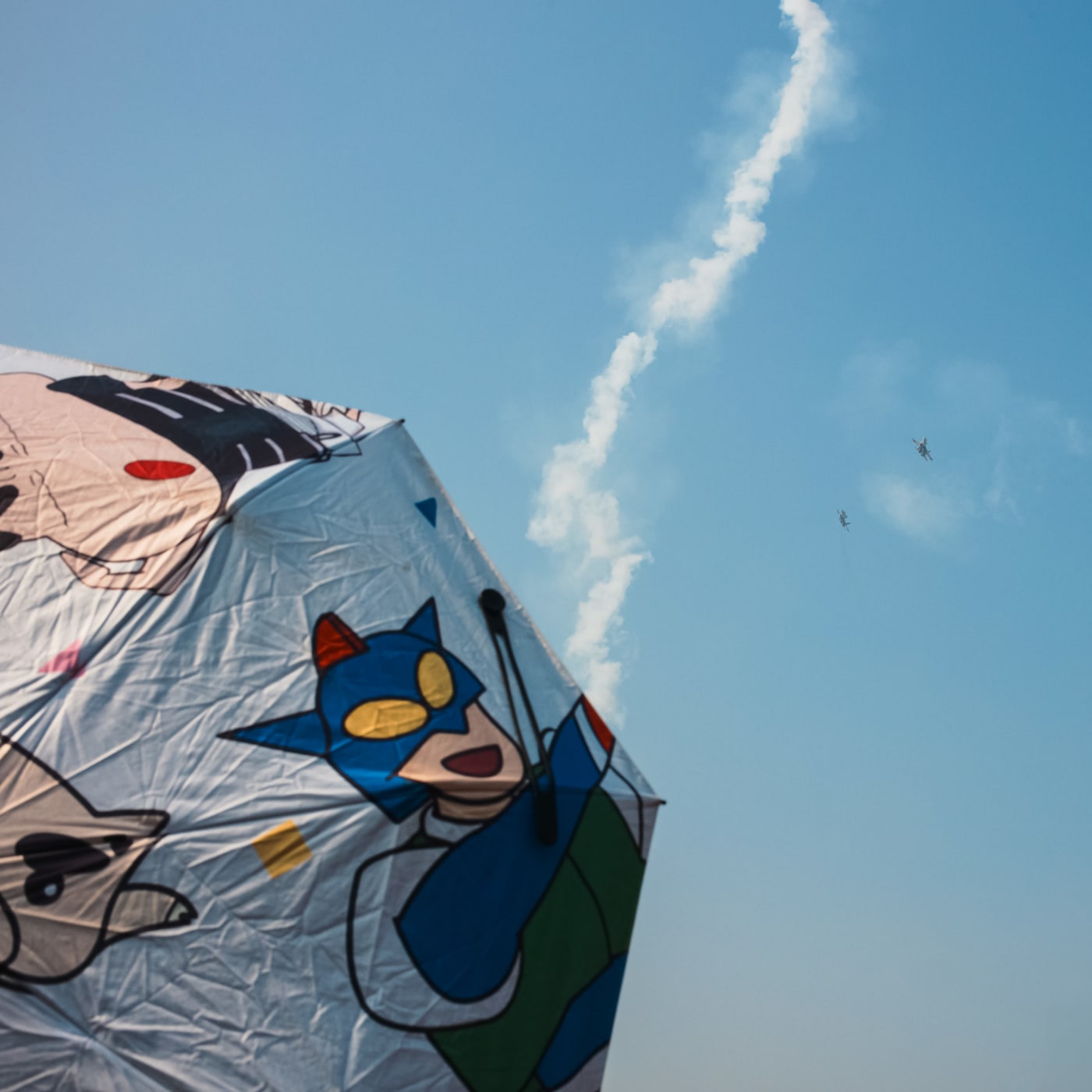 Cartoon umbrella with jet trail and helicopters in sky — Le Hoang Tuan