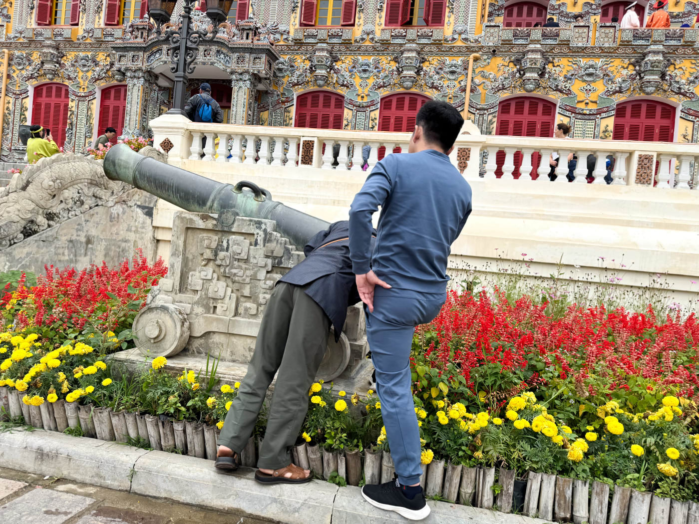 Person peers into a cannon at Hue Citadel — Le Hoang Tuan