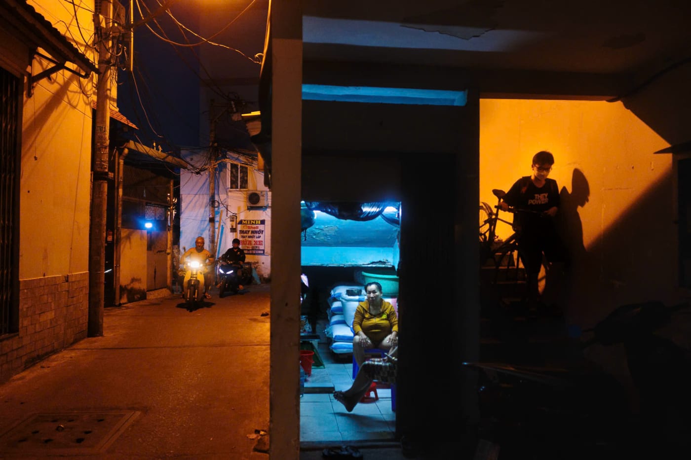 Night scene at an alley corner with warm and cool light splitting the frame — MatDat.Ng