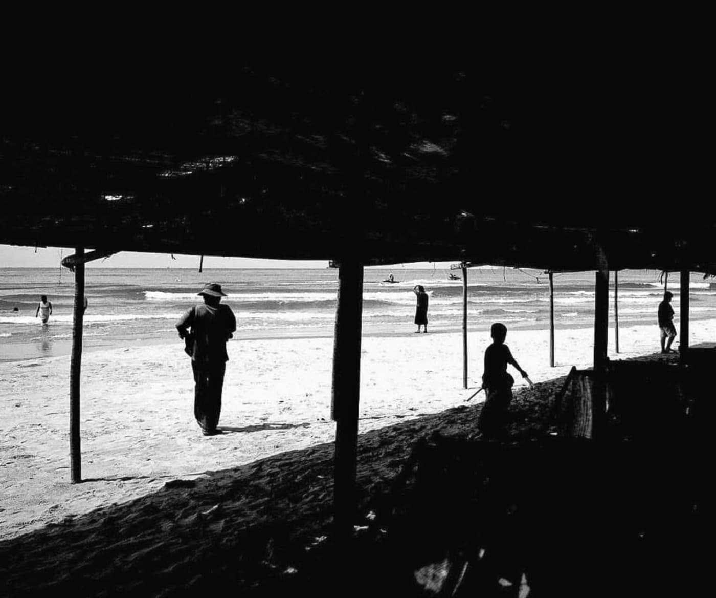 Silhouettes beneath a beach shelter looking out to sea, Vung Tau — MatDat.Ng