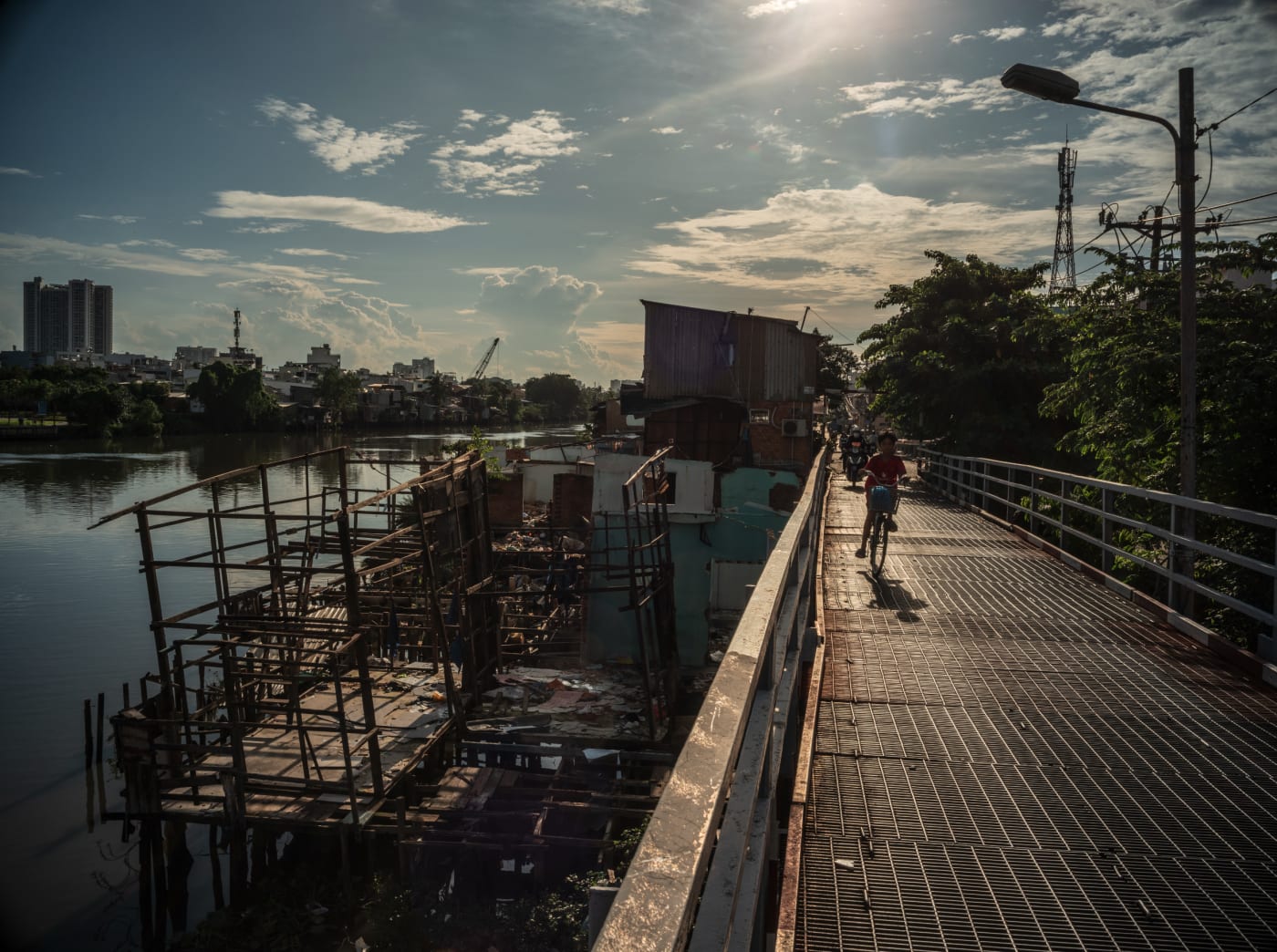 Bridge over canal with informal housing below, District 8 — Alexandre Garel
