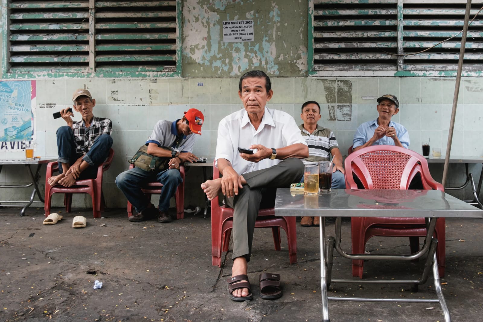 Men at a roadside café in Vietnam meet the photographer's gaze directly