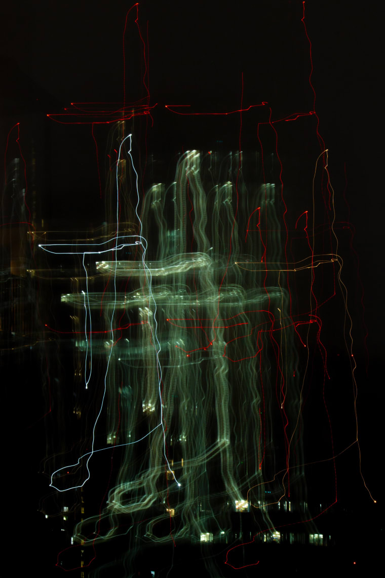 Nhất thể — green and red light trails written across black by a moving camera — Lâm Xuân Tùng