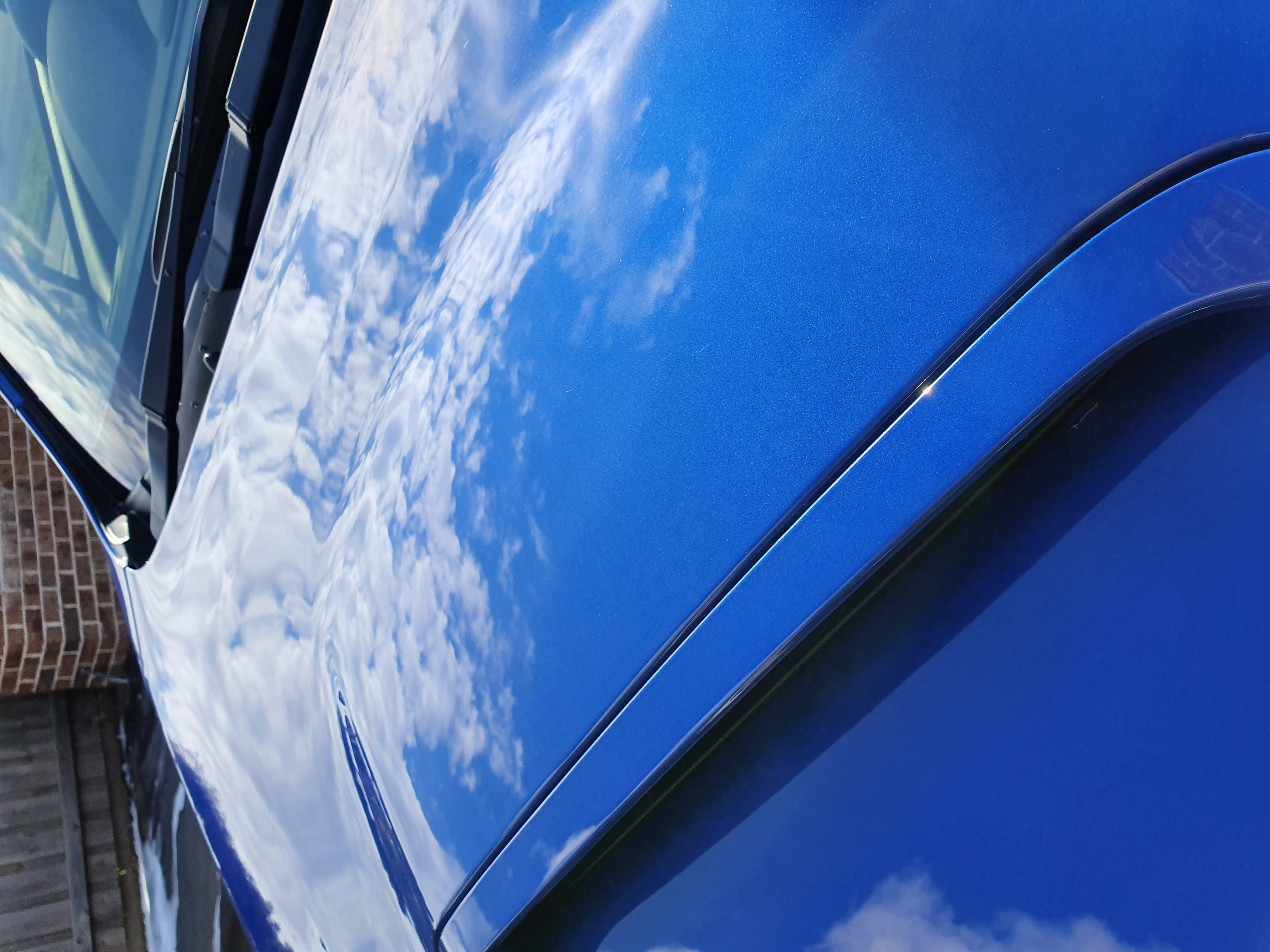 WR Blue Pearl paint detail — clouds reflected in the bonnet