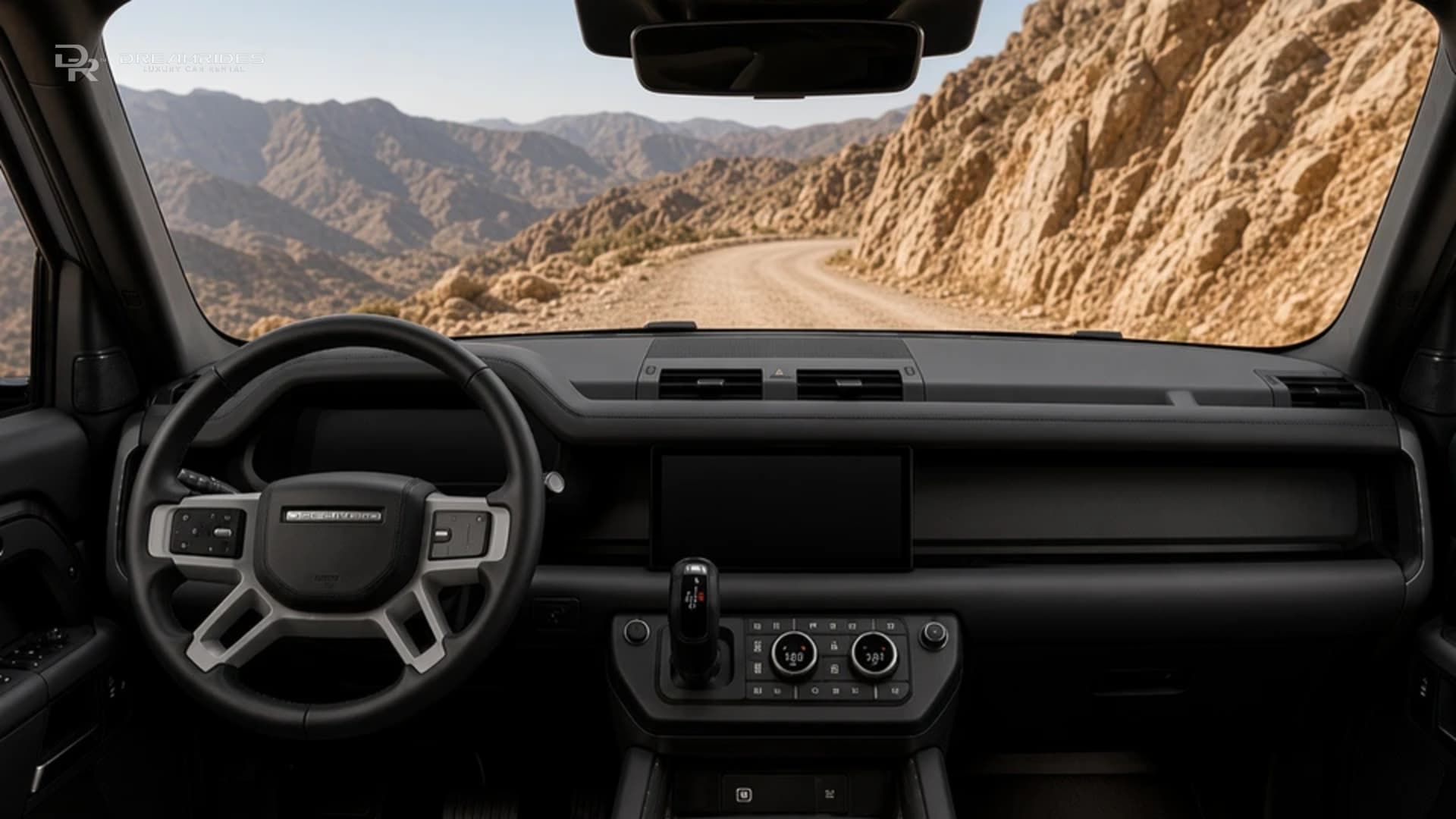 Land Rover Defender 110 black cabin and dashboard looking out at a Hajar mountain road for a G63 vs Defender rental Dubai driver view