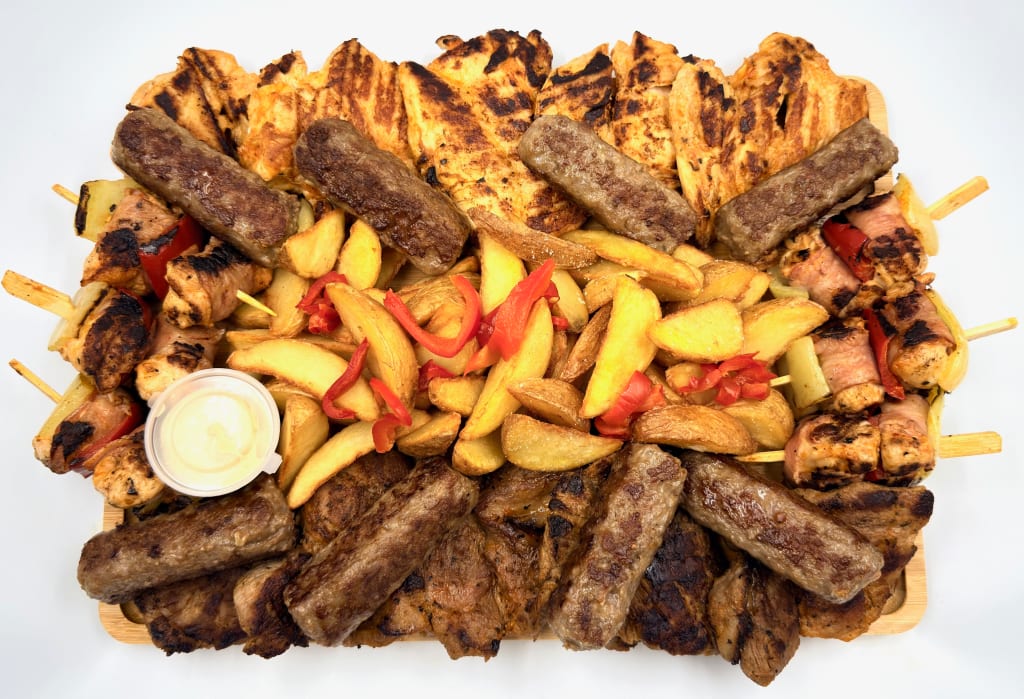 Platou drerptunghiular 23 bis - contine piept de pui la gratar (350g), mici (8 buc), mustar (50g), cartofi wedges (400g), frigarui de pui cu bacon (6 buc), ceafa de porc la gratar (350g), muraturi in otet (castravete si gogosar) (100g) - recomandare de consum 4-5 persoane - 236 lei. Pretul afisat este cel cu reducerea de 10% aplicata.