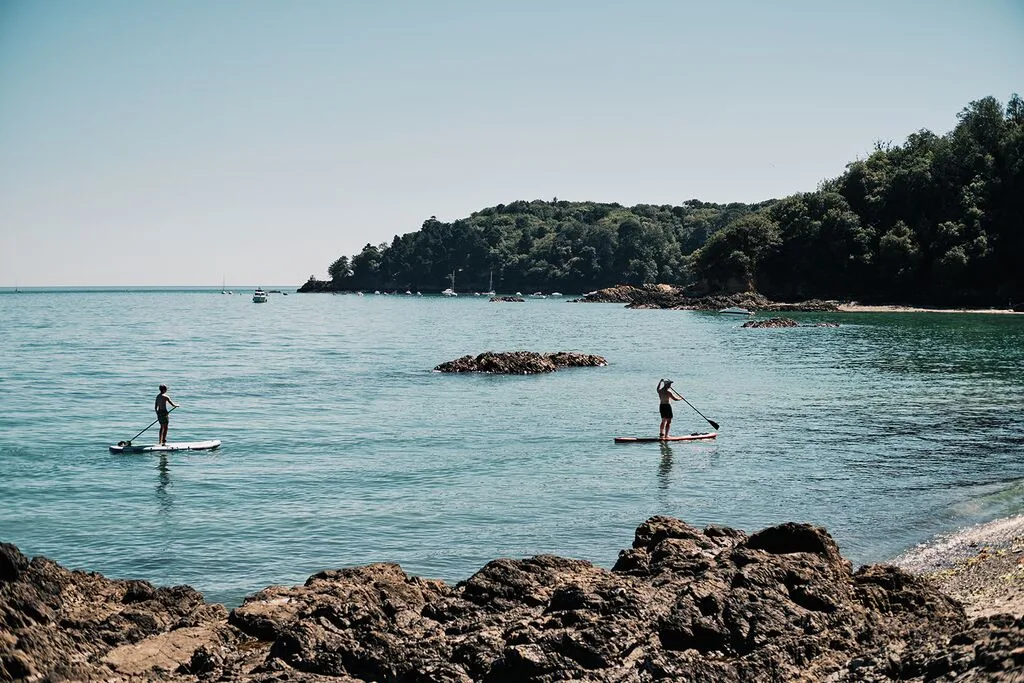 People paddle boarding in St Aubin's Bay