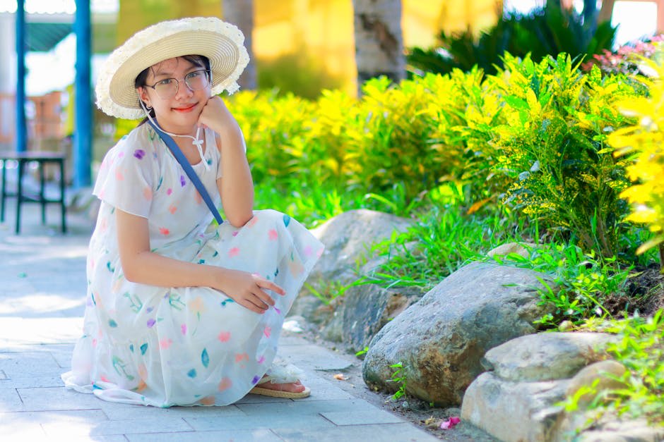 Cách phối chân váy hoa mùa xuân - Người phụ nữ mặc váy hoa và đội mũ che nắng đang tận hưởng một ngày nắng trong khung c