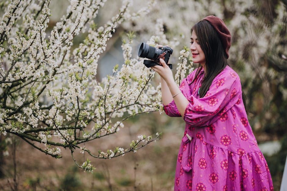 Đầm hoa nhí mùa xuân - Nữ nhiếp ảnh gia đang chụp ảnh hoa mùa xuân nở rộ ngoài trời.