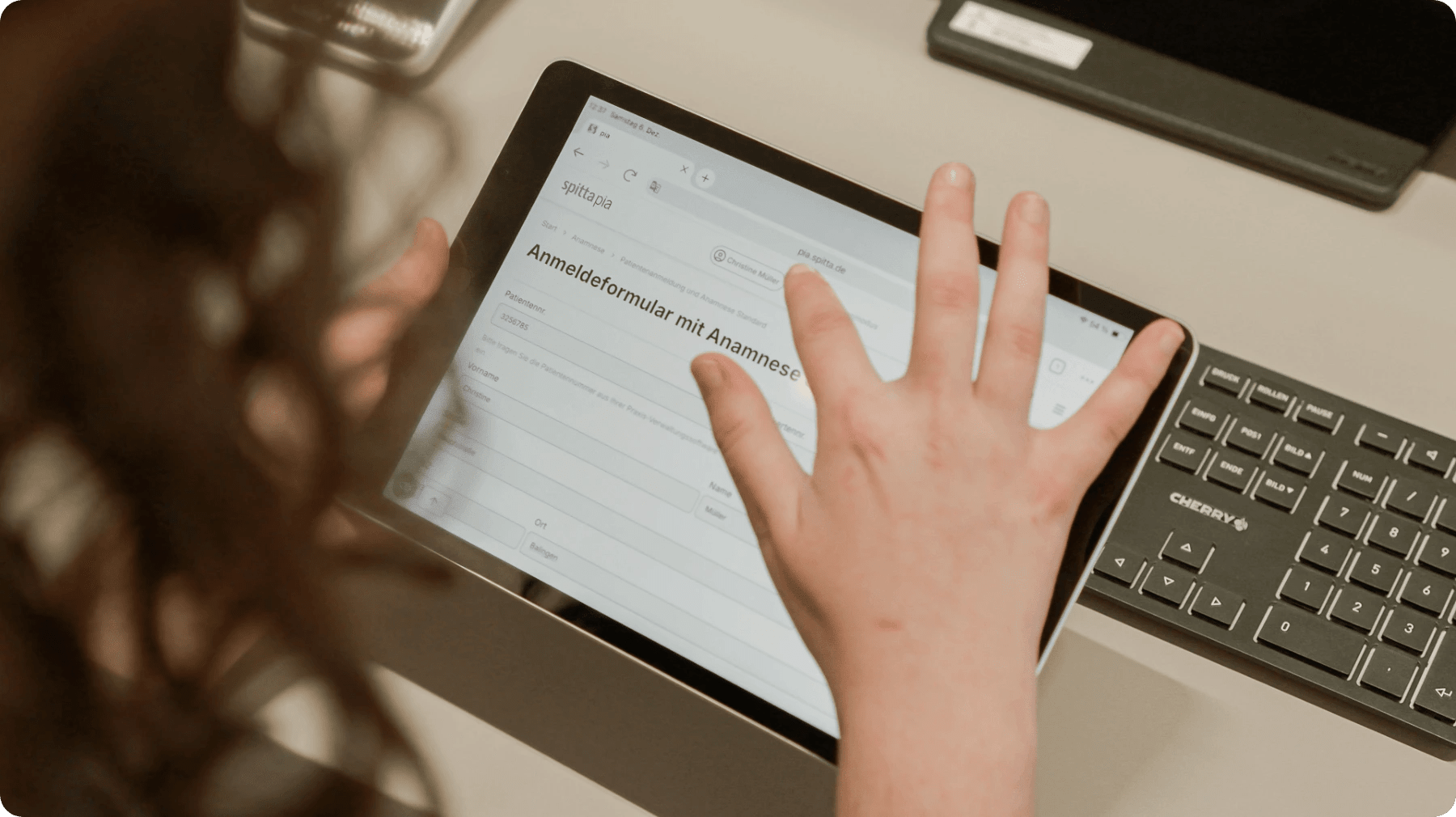 Praxismitarbeiterin kontrolliert die Angaben eines ausgefüllten Anamnesebogens