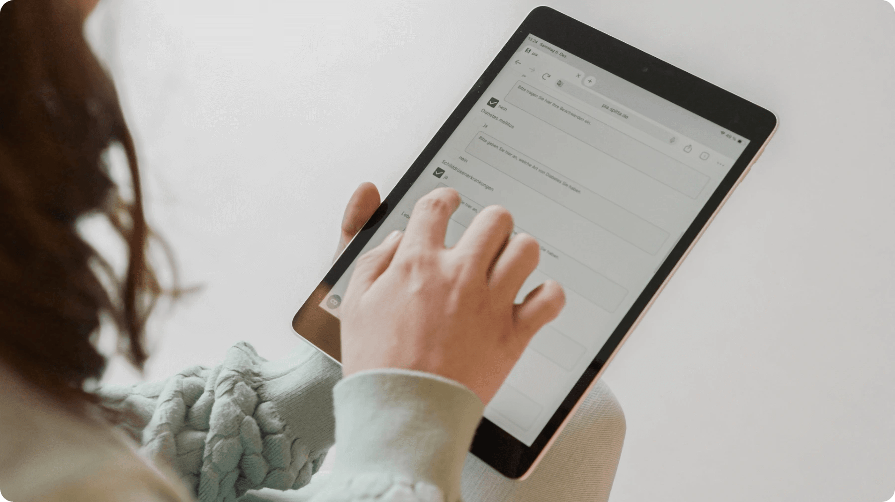 Patientin füllt Anamnese am Tablet im Wartezimmer einer Zahnarztpraxis aus