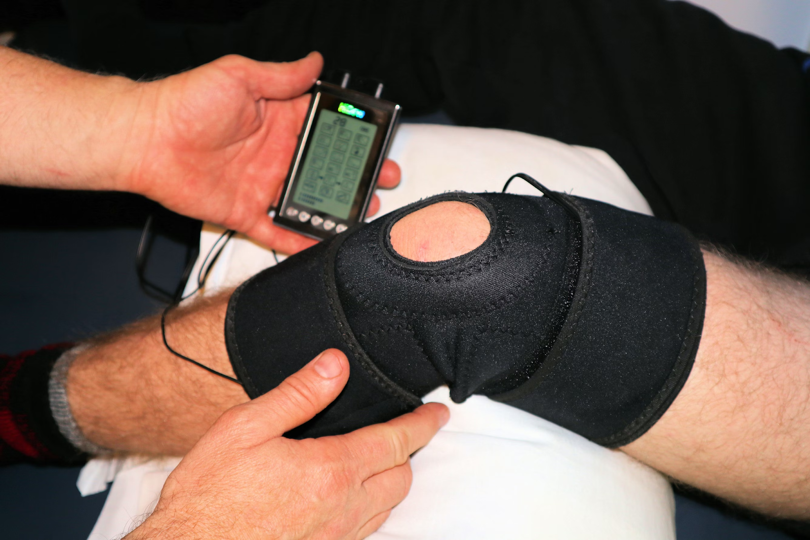 A close up shot of someone's knee in knee support during physical therapy.