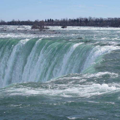 Yeşil ormanda akan bir şelale, doğanın gücünü ve güzelliğini temsil ediyor.