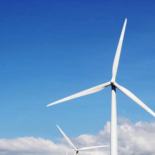 Güneş panelleri ve rüzgar türbinleri ile yeşil enerji üretimi görseli