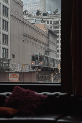 An image of a urban, cityscape, and travel engaged in reading with a introspective atmosphere.
