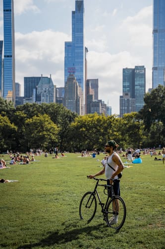 An image of a cityscape and urban engaged in reading in a park.