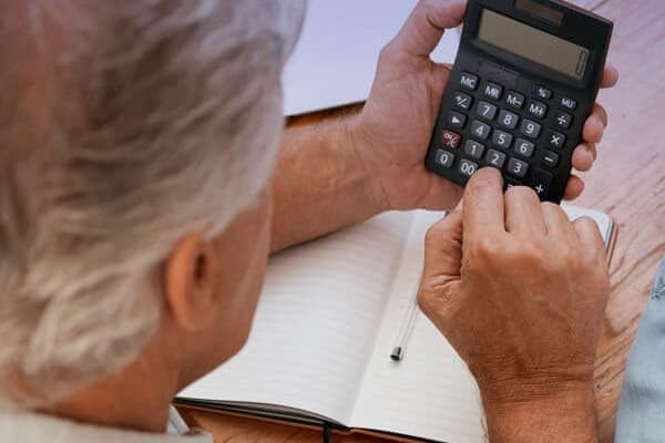 Person beregner pensjon på nett med laptop hjemme i 2025