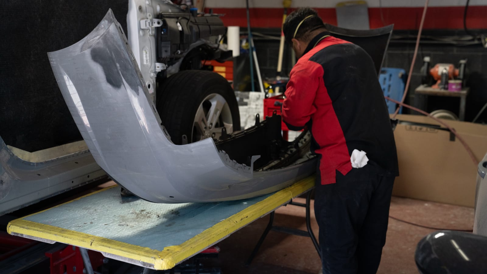 Pristine technician fitting a bumper on the bench