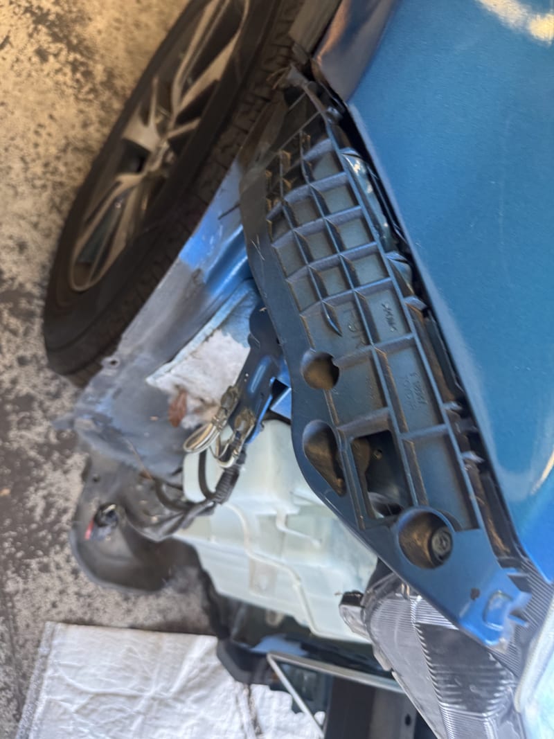 Blue SUV bumper bracket and fender damage