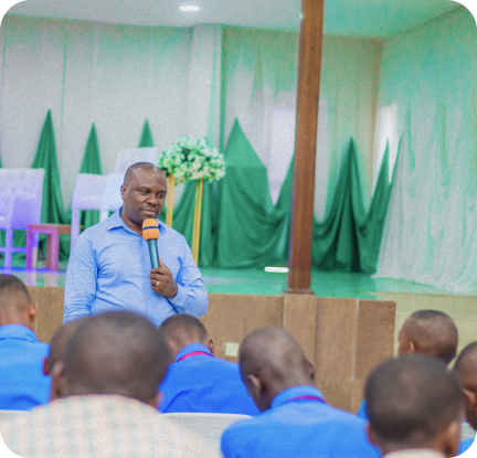 Community leader speaking to an engaged audience, representing capacity building and leadership development