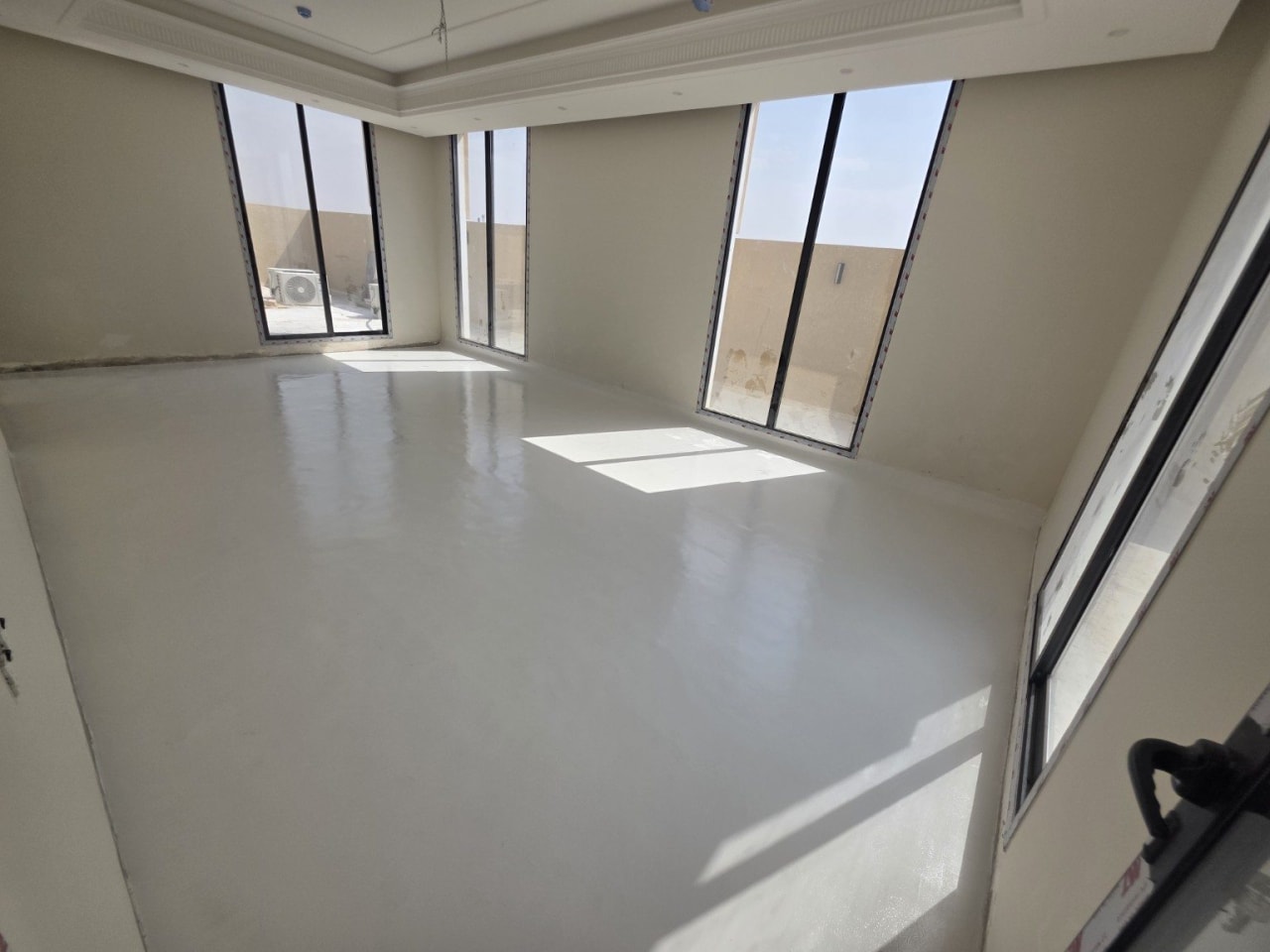 Finished light microcement studio floor with natural daylight in Dhahrat Laban, Riyadh