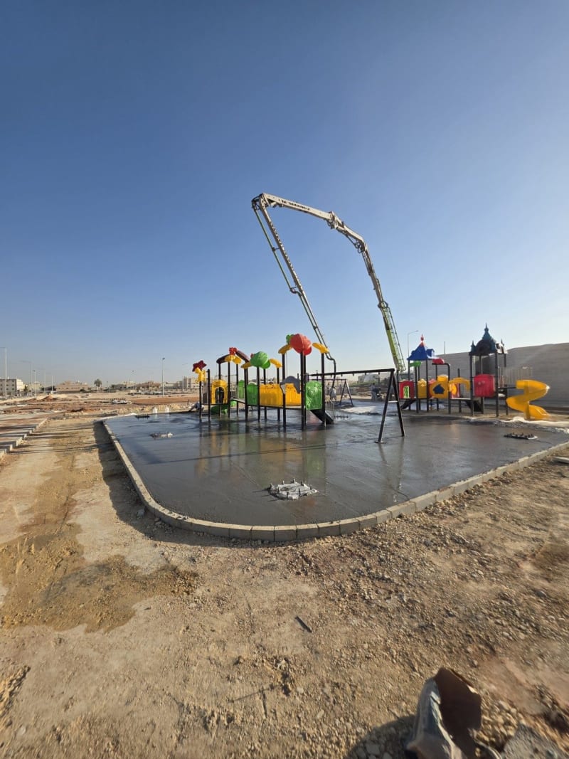 Concrete being placed around fixed playground structures during the 550 m² project in As Saadah, Riyadh
