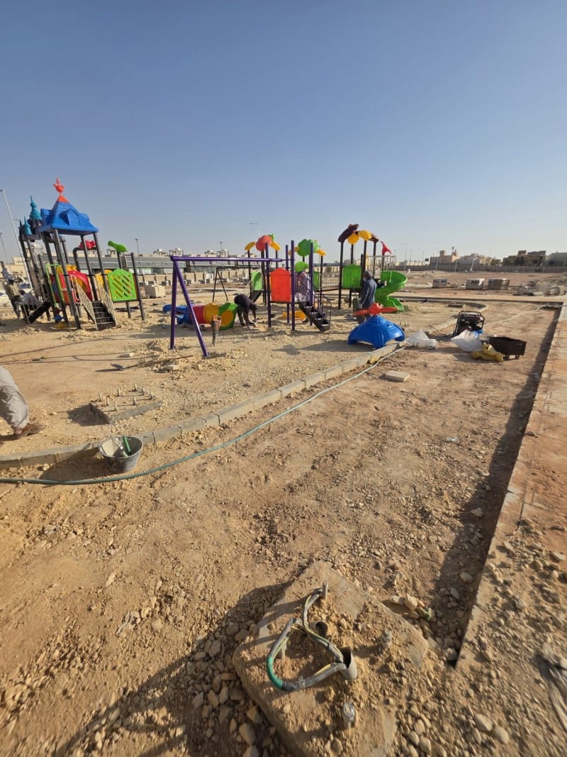 Unfinished ground around installed playground equipment before the concrete base work in As Saadah, Riyadh