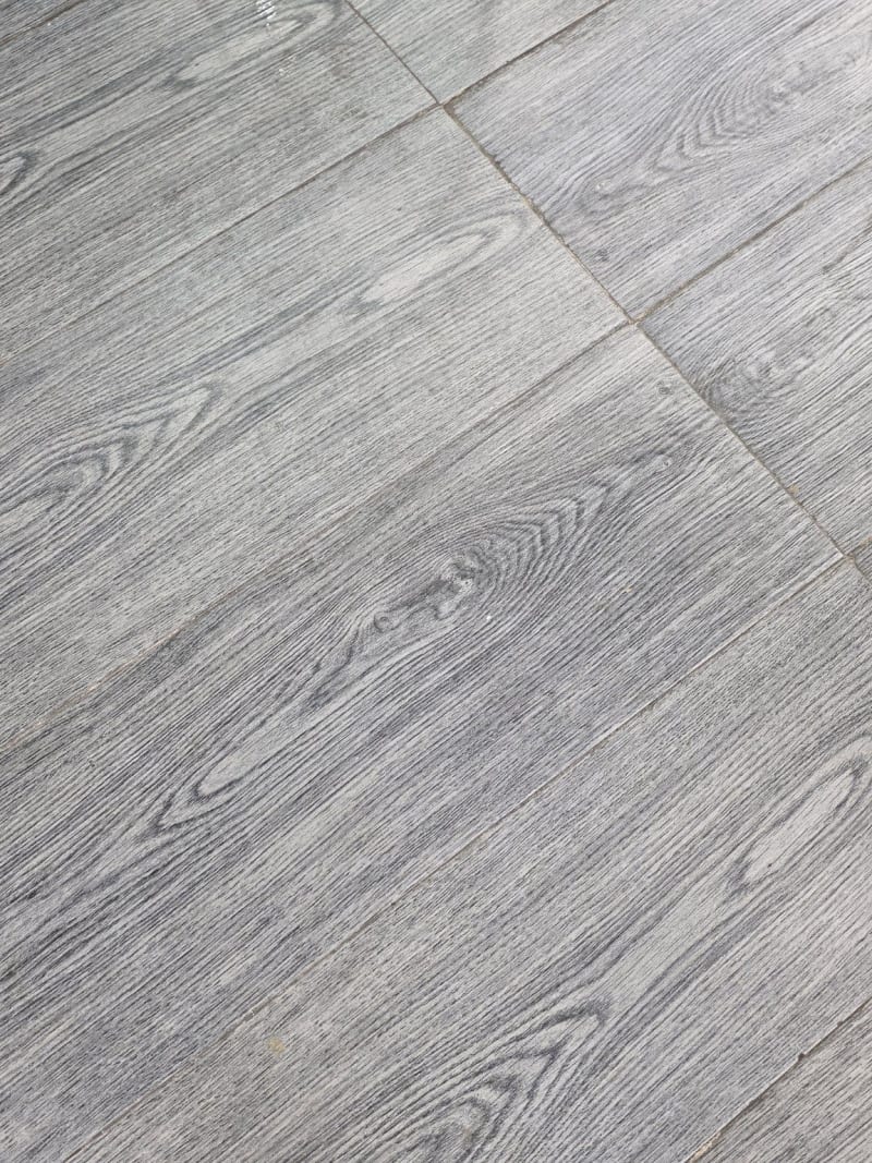 Existing grey wood-look tile floor inside Tawasul-Tech mobile repair shop in Al Bathaa, Riyadh, before renovation