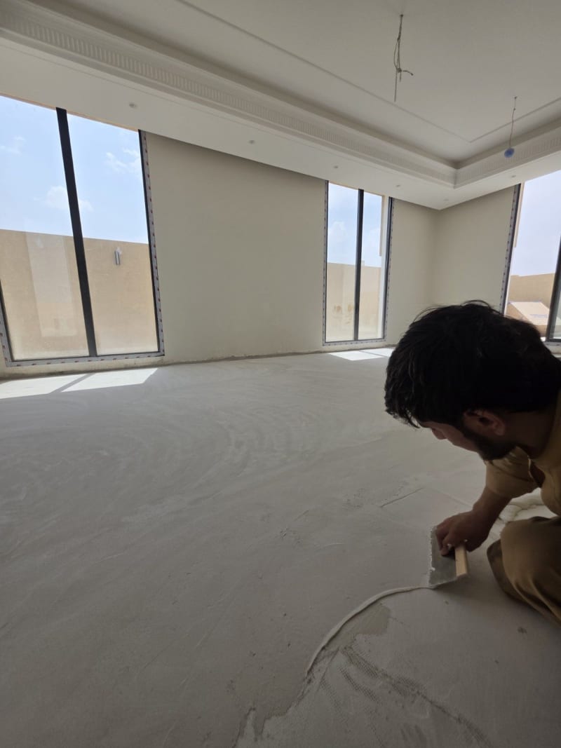 Microcement flooring being hand applied inside a daylight-filled studio in Dhahrat Laban, Riyadh