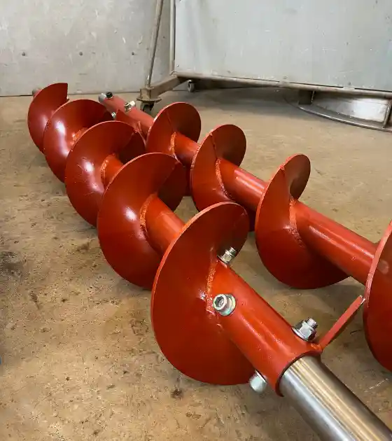 Caldeiraria Santa Rosa - Diversas transportadoras industriais, incluindo uma rosca, em pátio de fábrica.