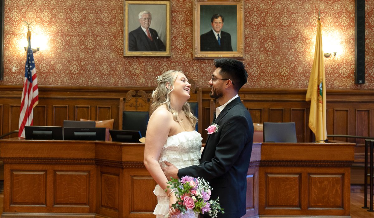 Newly married couple celebrating after intimate city hall ceremony at Cambridge Massachusetts with marriage certificate