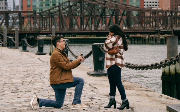 Newly engaged couple at Boston Seaport with harbor views and skyline