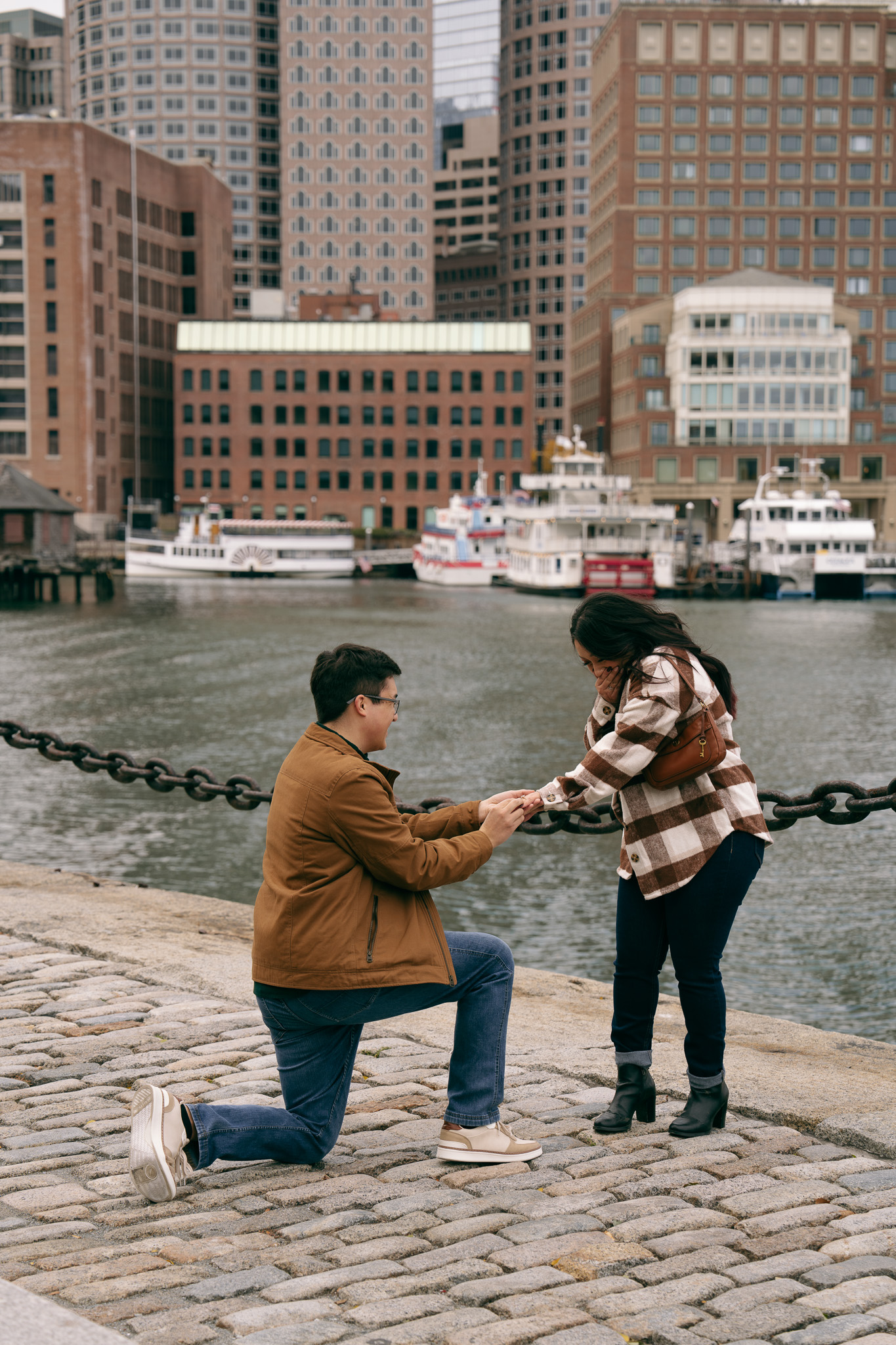 Ethan on one knee proposing at Boston Seaport