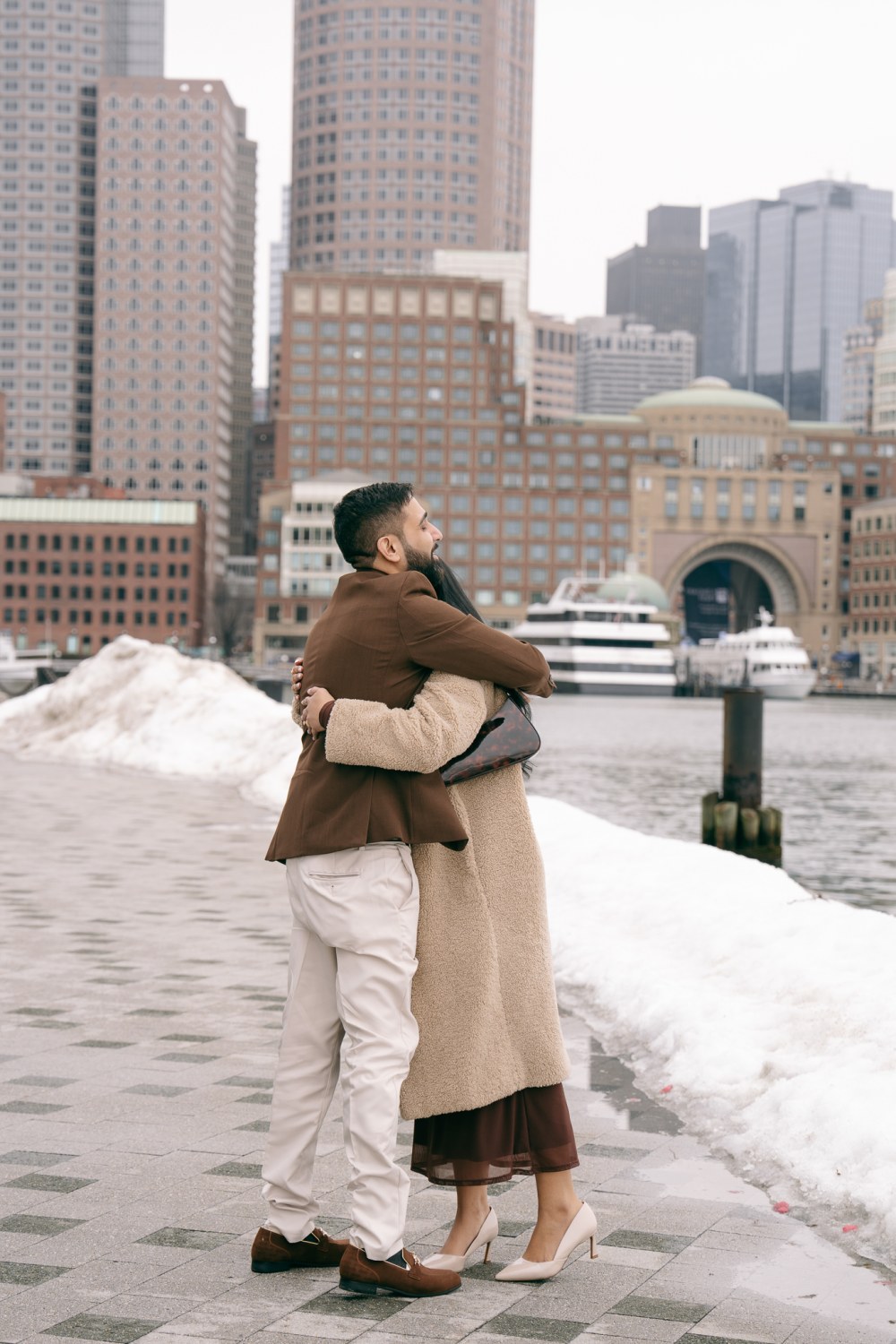 A proposal at Fan Pier in the Boston Seaport at golden hour with the skyline across the water
