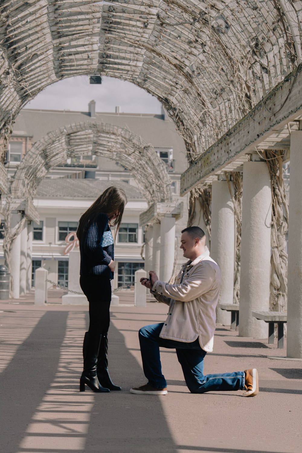 Ben on one knee proposing to Ally at Christopher Columbus Park