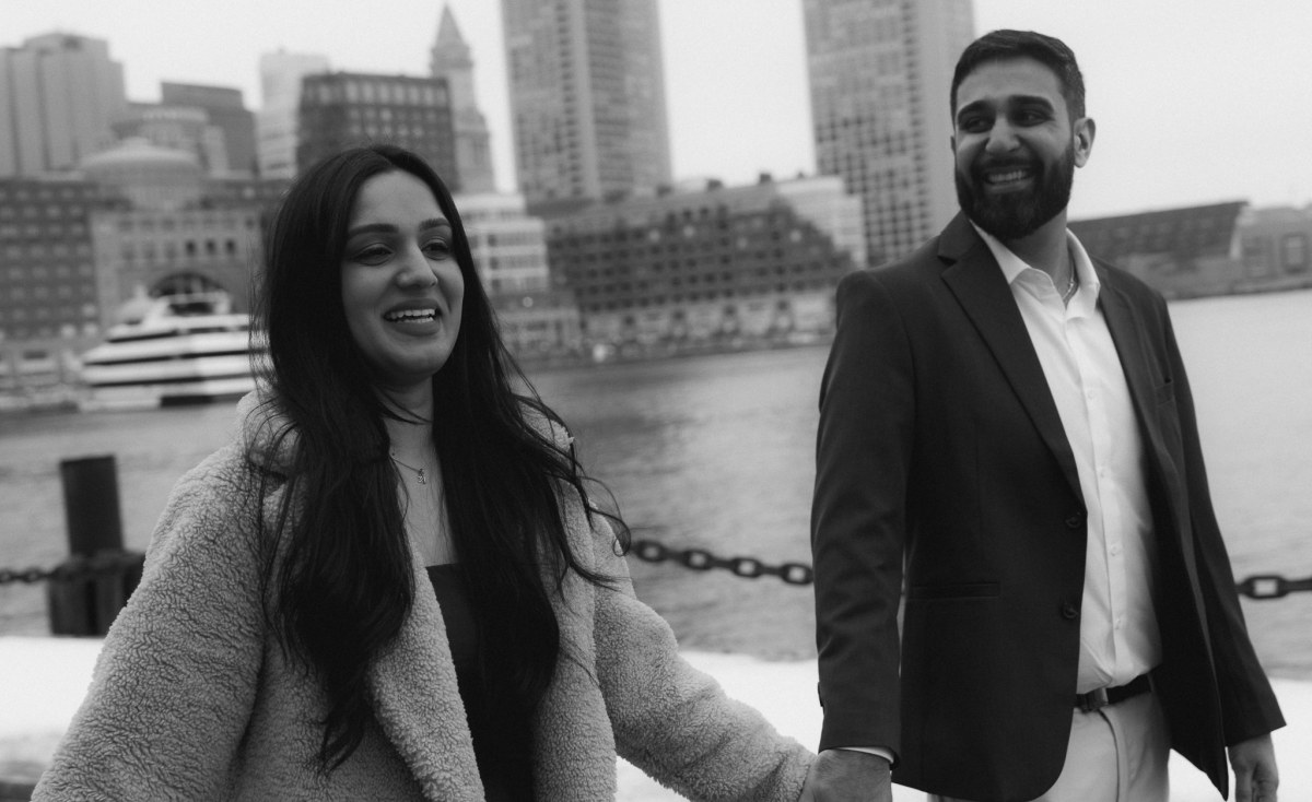 An engagement portrait at Fan Pier with the Boston Seaport skyline behind the couple