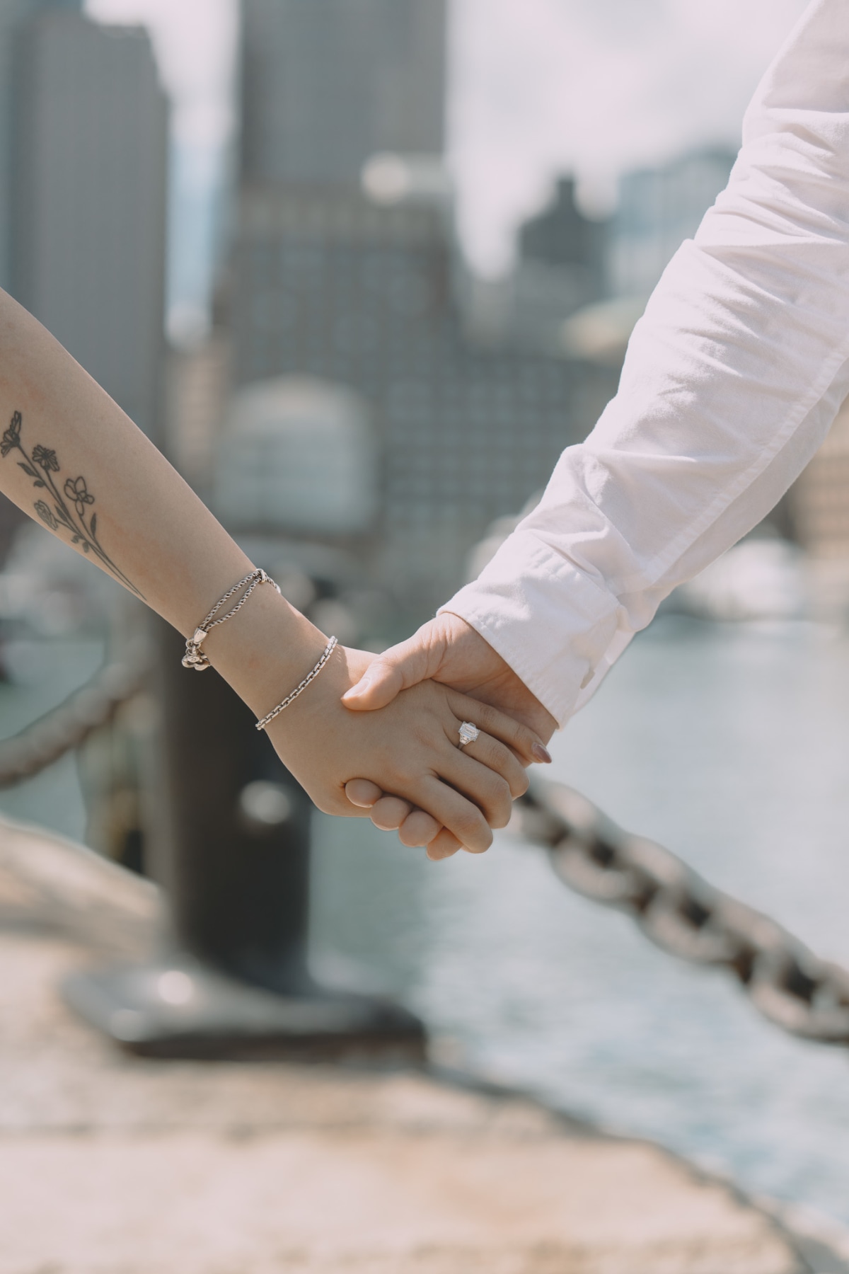 A couple embracing at the Boston waterfront with sunset behind