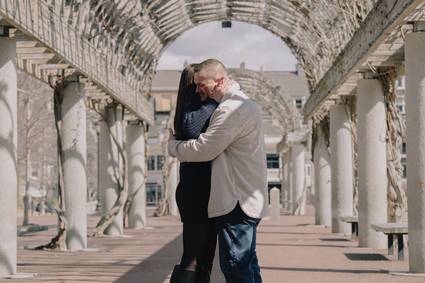 Wide view of Ben and Ally at Christopher Columbus Park after the proposal