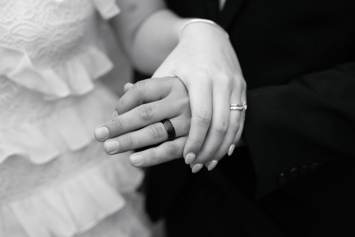 Wedding rings and joined hands