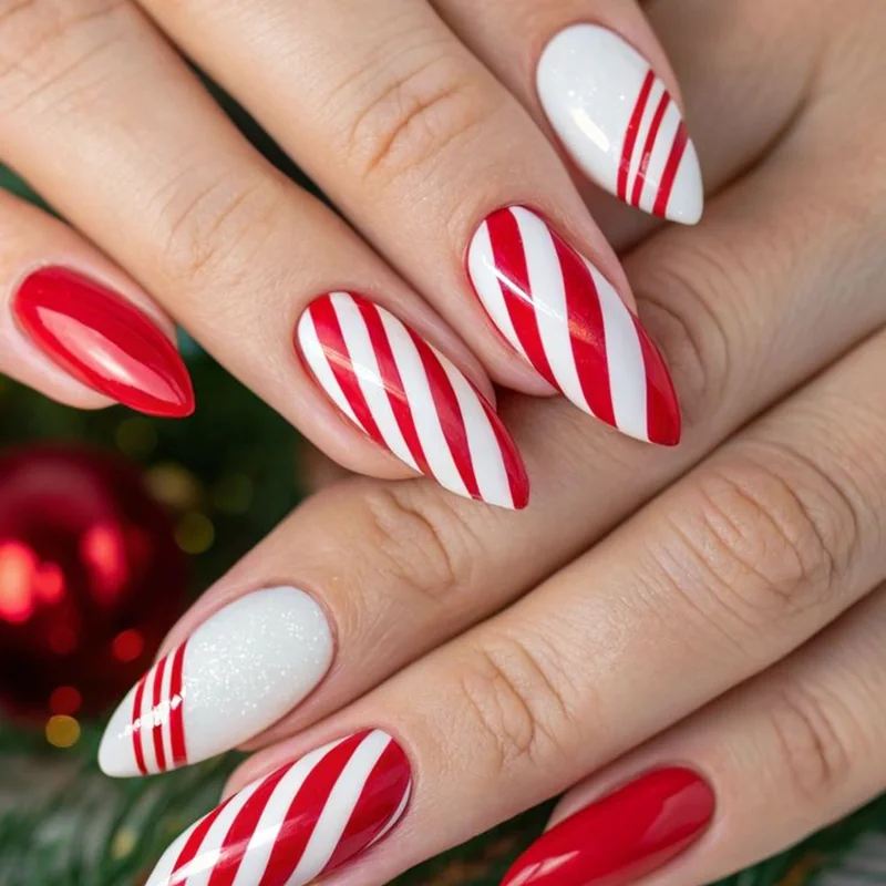 Diagonal red and white candy cane striped nails perfect for Christmas 2025 celebrations