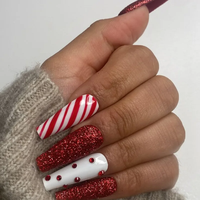 Sparkling candy cane nails with red glitter accents for glamorous holiday parties