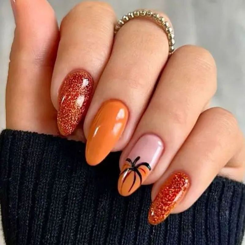 Bright orange pumpkin nail design with brown stem and ridge details for easy Halloween manicure