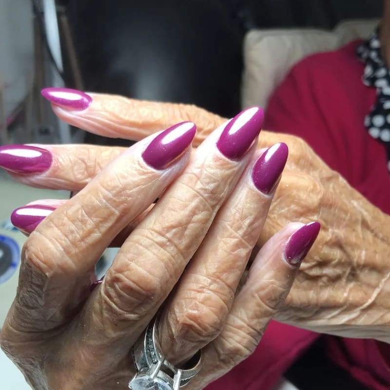 Dark burgundy nail polish versus medium warm tones on mature hands showing aging contrast effect