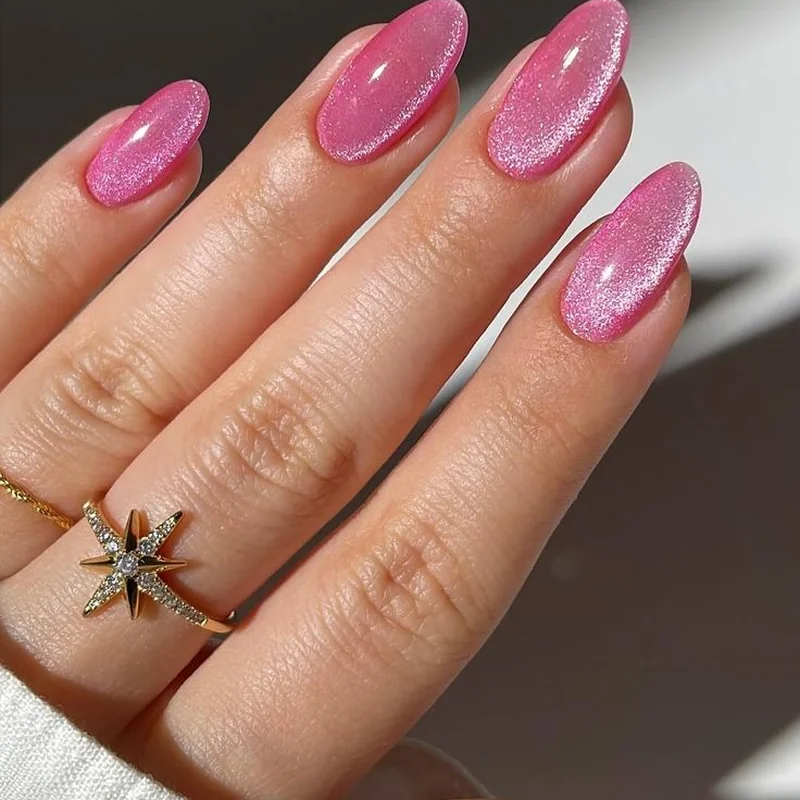 Magnetic particles aligning in pink gel polish creating dimensional cat eye shimmer effect